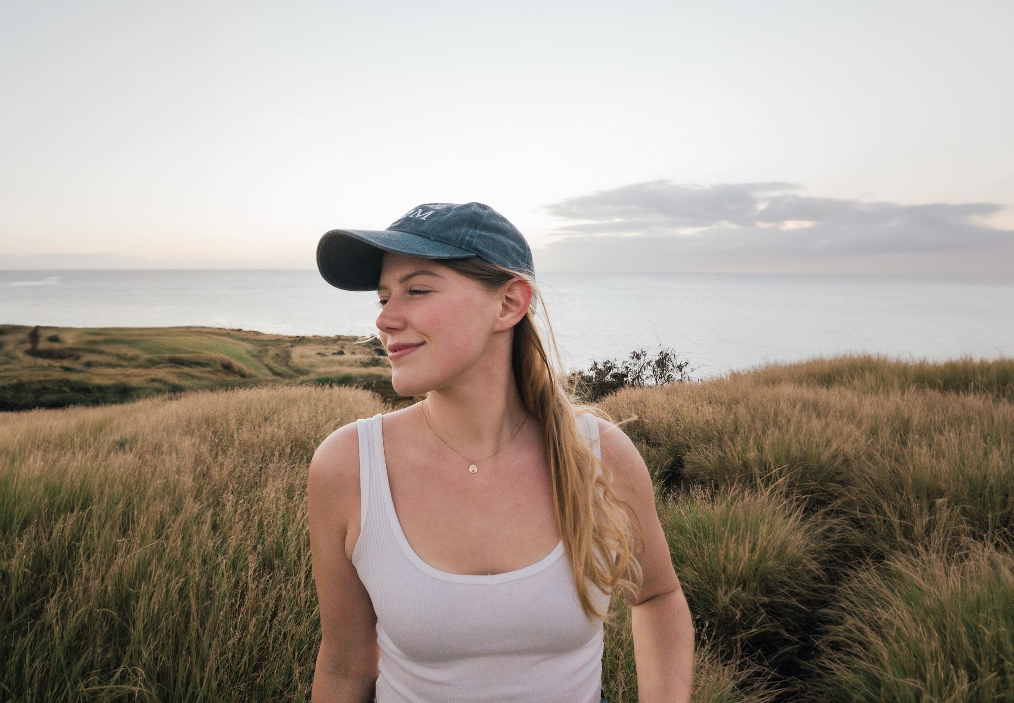 Cassie Stone outdoors on a coastal hillside at golden hour